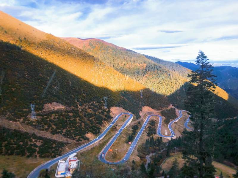山间蜿蜒公路 夕阳染金峰峦图片