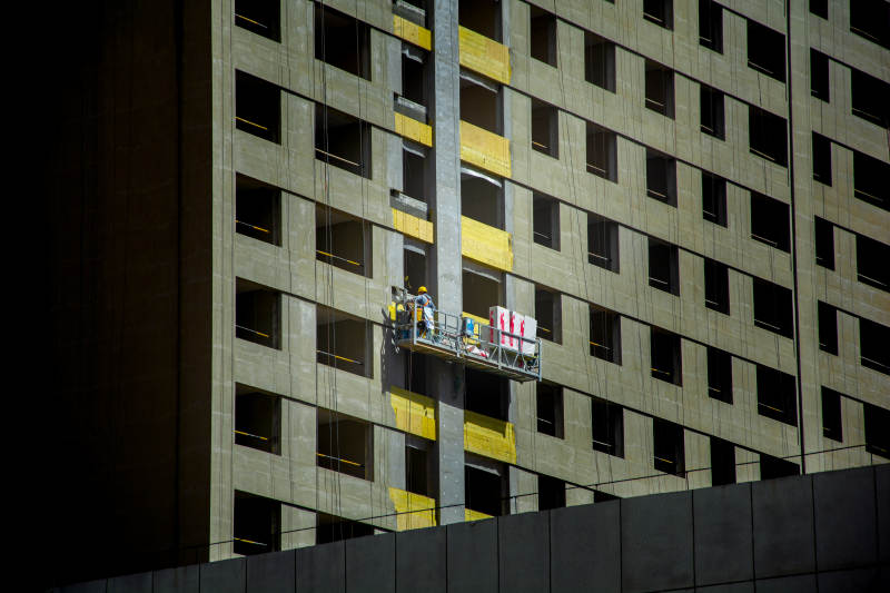 高楼外墙施工中的工人图片