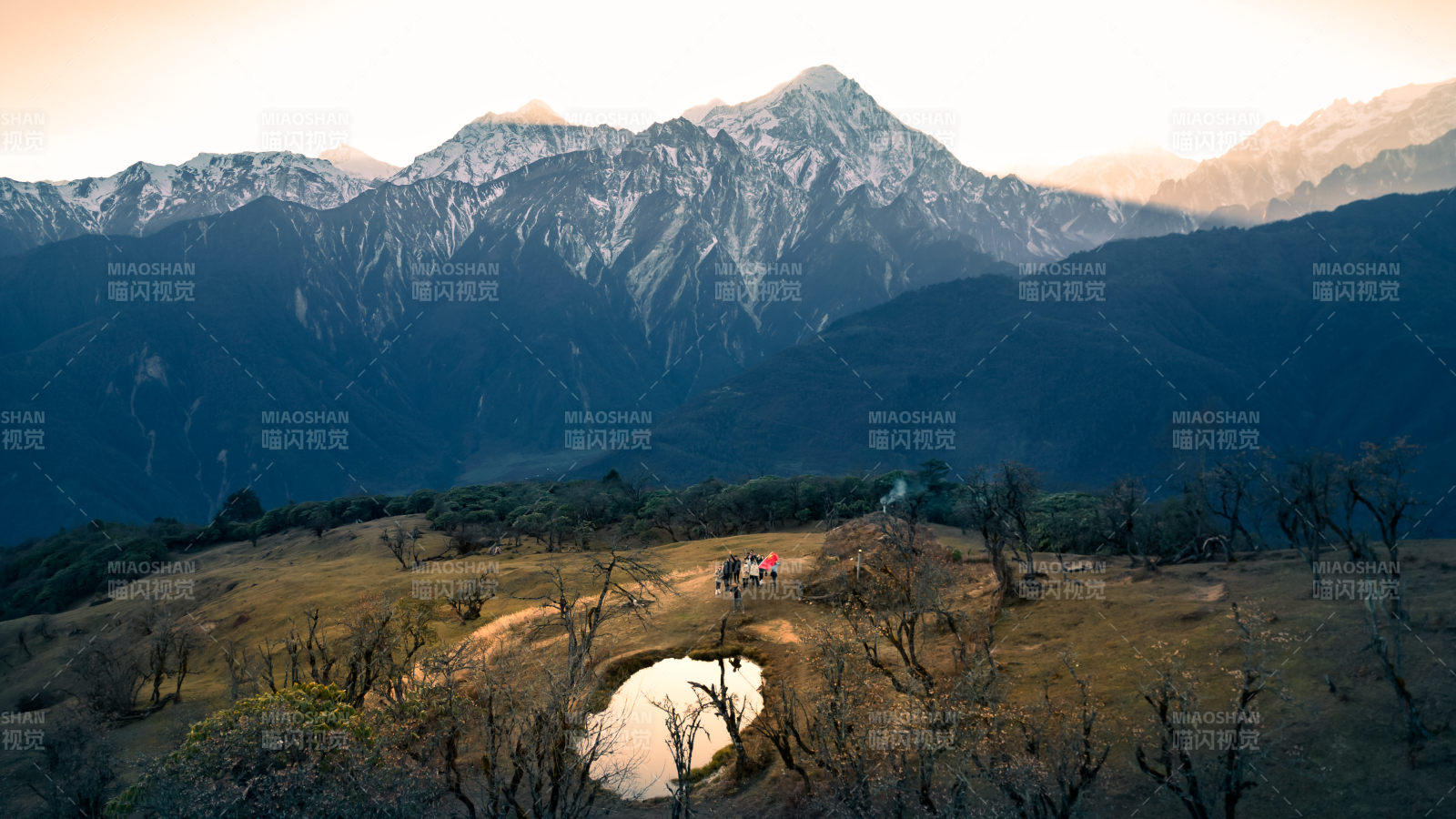 雪山下的徒步者与小湖图片