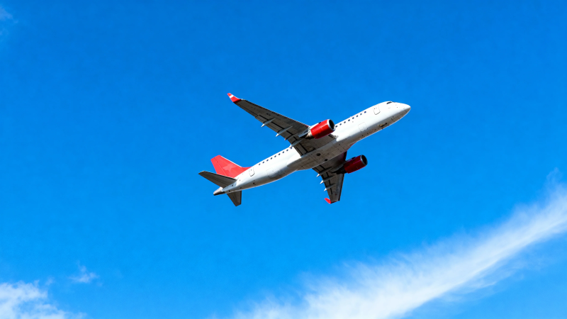 蓝天下的红尾客机飞行中图片