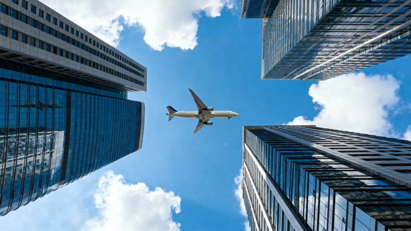 飞机掠过摩天楼群图片