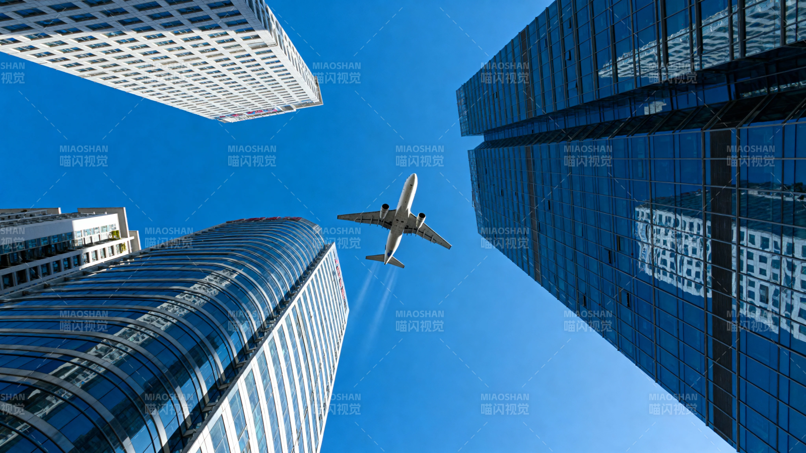 飞机掠过摩天楼群图片