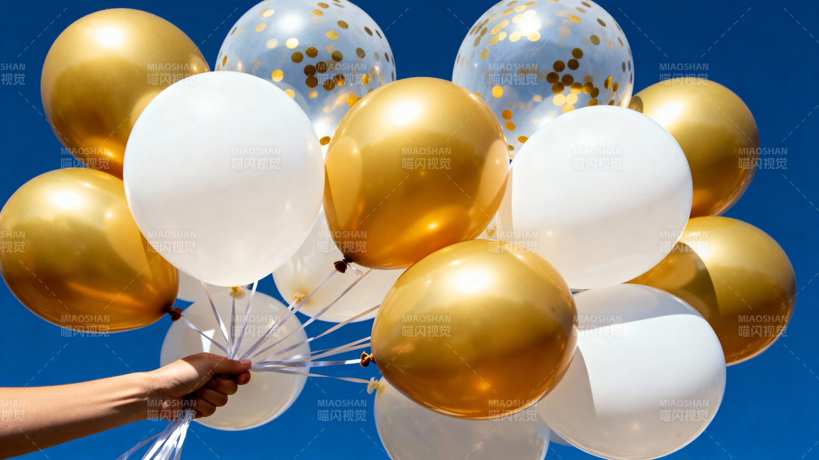金白气球手握蓝天背景图片