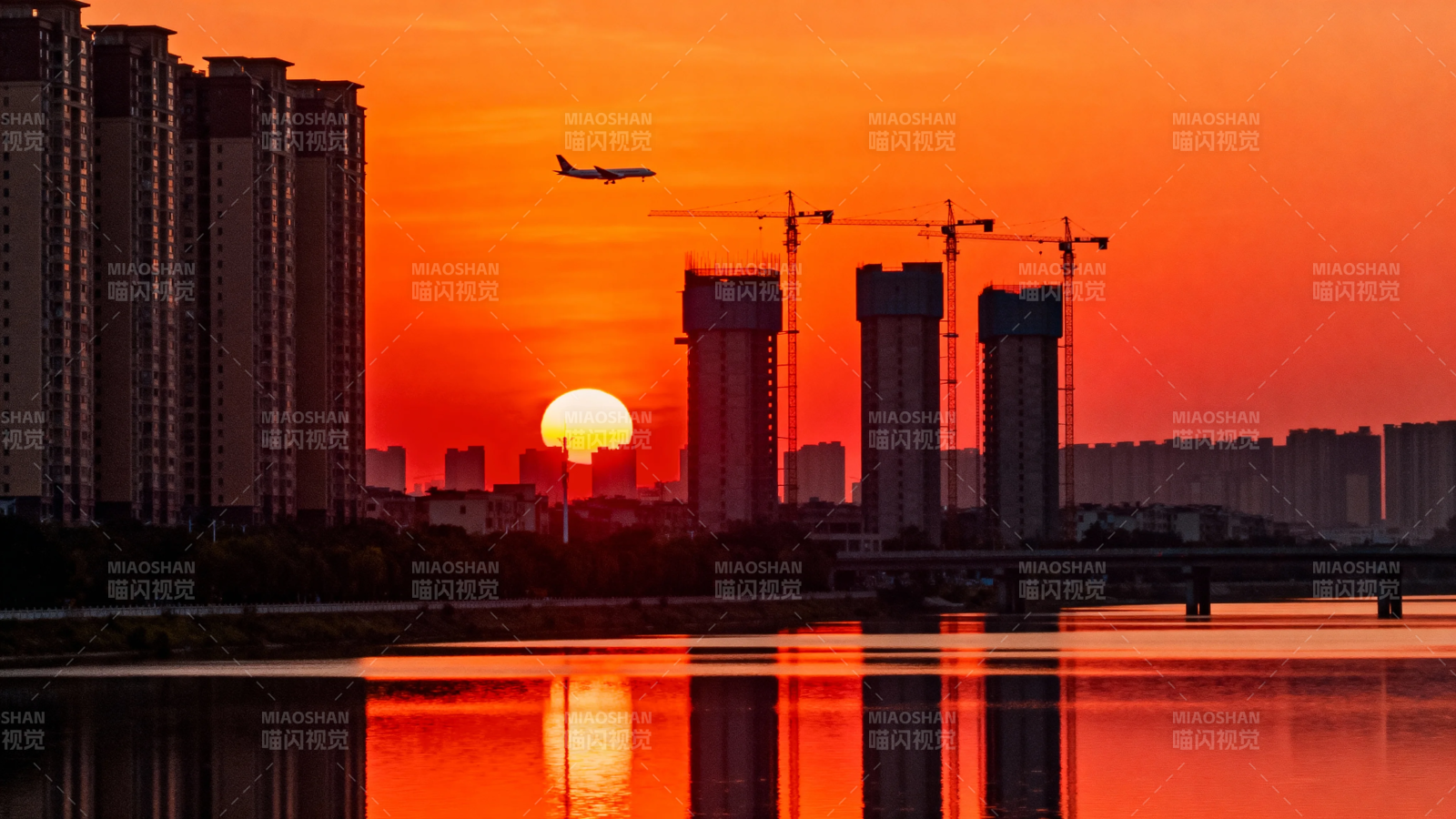 夕阳映城 飞机掠塔影图片