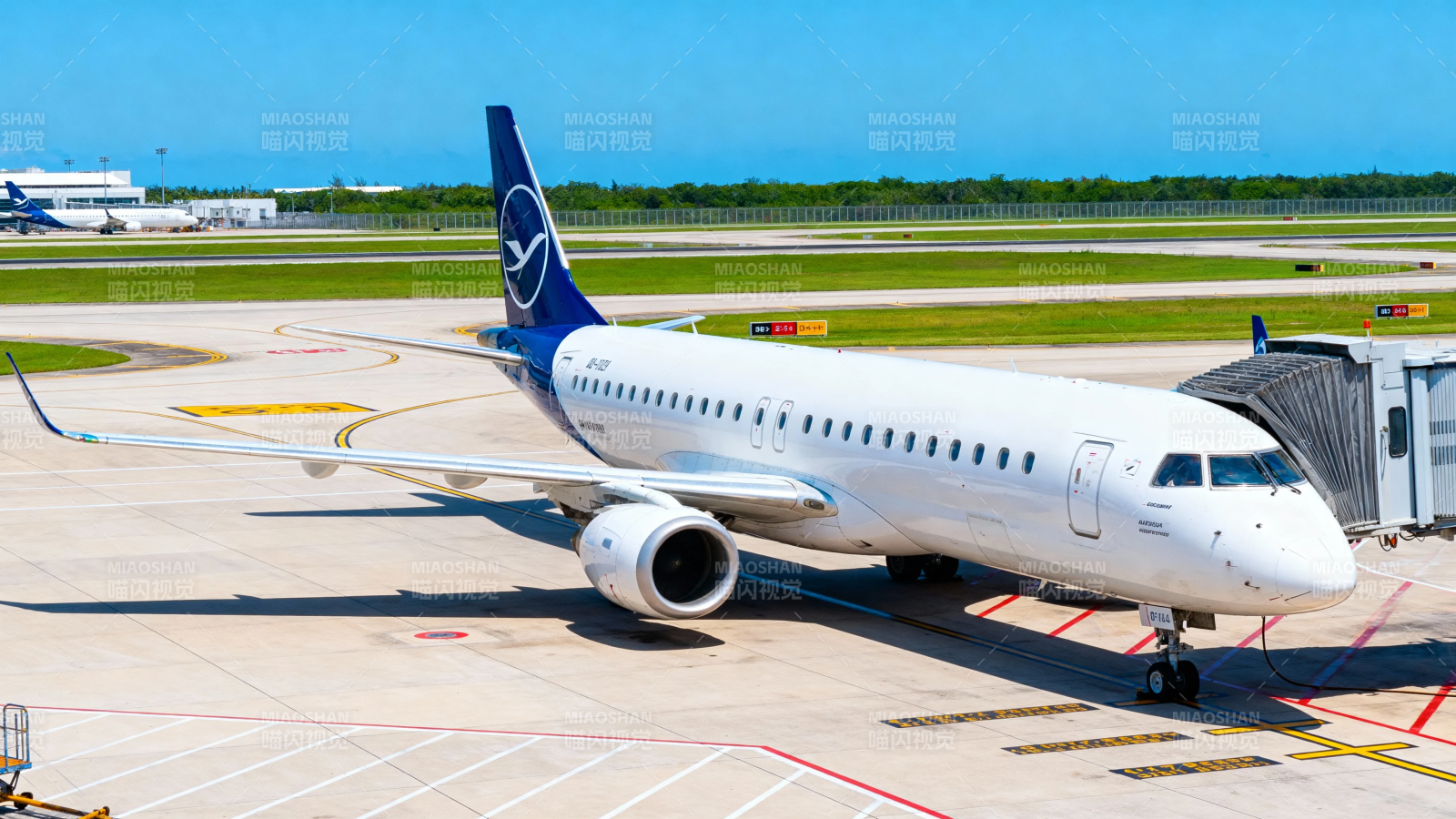 客机停靠登机桥 蓝天映衬机场景图片