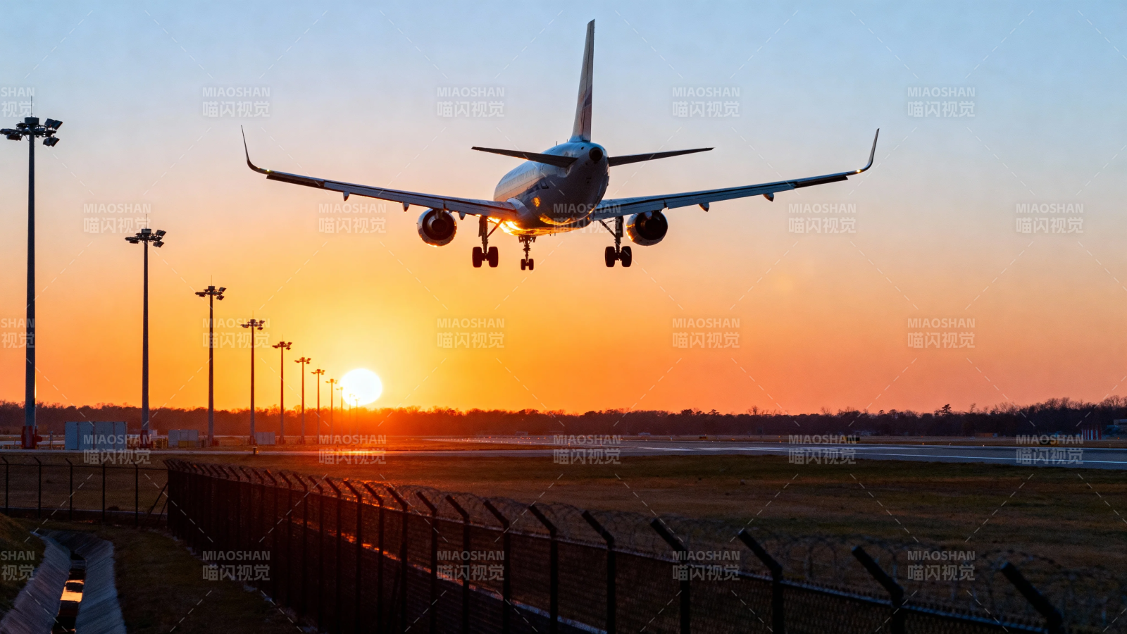 夕阳下飞机降落瞬间图片