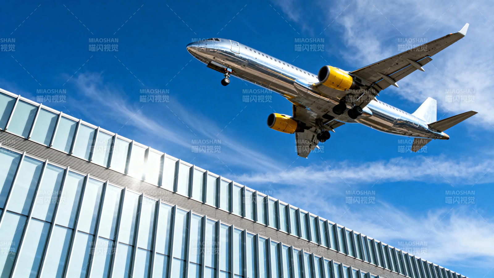 飞机掠过现代玻璃建筑上空图片