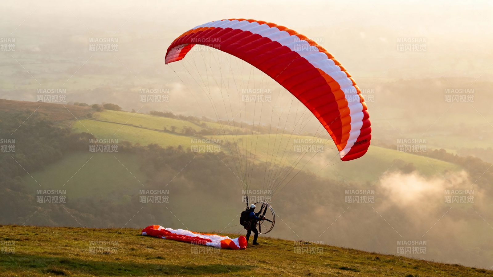 滑翔伞起飞 红白翼展山巅图片
