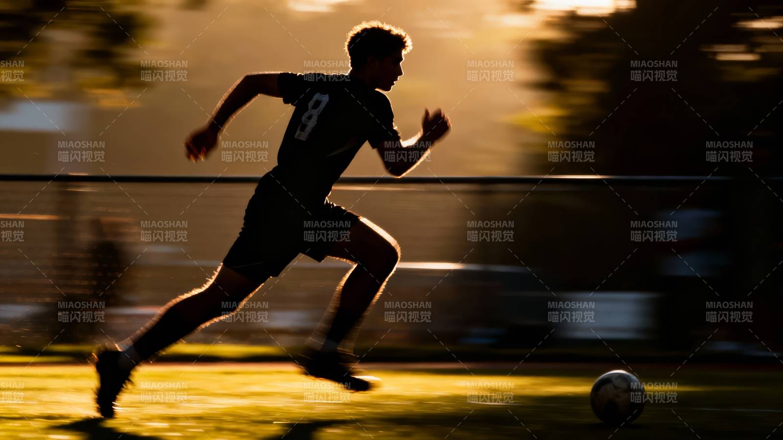 夕阳下奔跑的足球少年图片