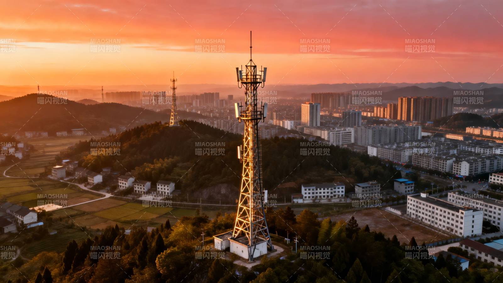 夕阳下的通信塔与城市远景图片