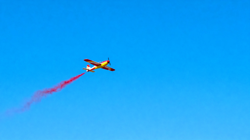 红黄飞机拉烟飞蓝天图片