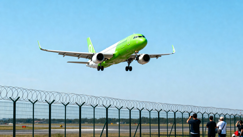 绿白客机起飞 围栏外人仰望图片