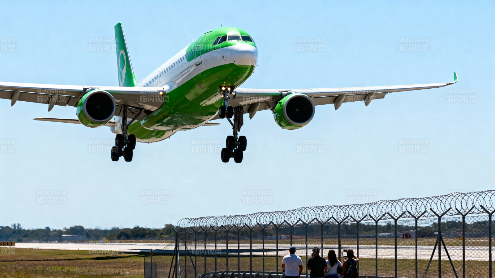 绿白客机低空降落机场图片