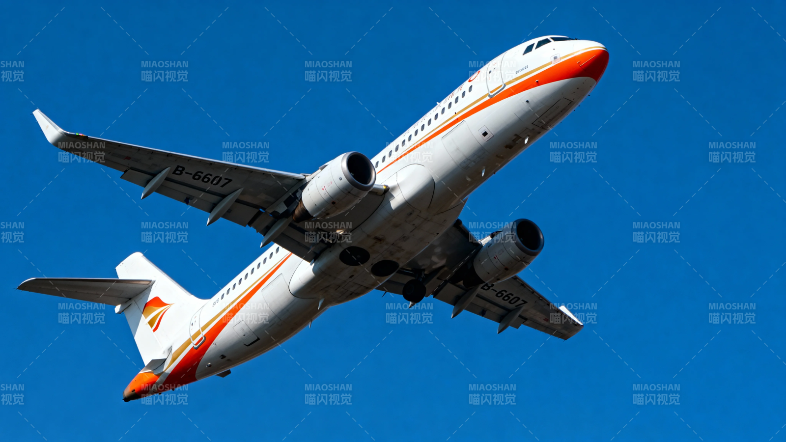 橙白客机蓝天翱翔图片