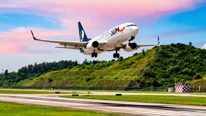 飞机起飞 蓝天绿地相映图片