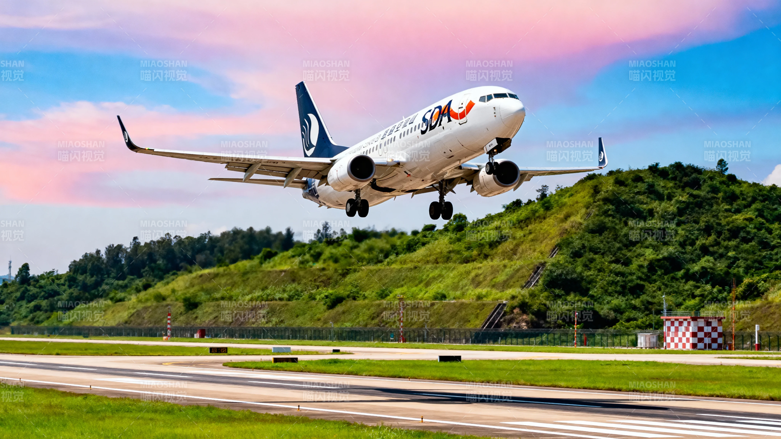 飞机起飞 蓝天绿地相映图片