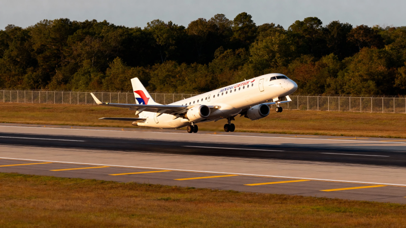 客机起飞瞬间 背景绿树成荫图片