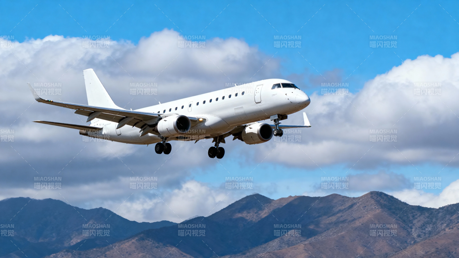 飞机掠过山峦 云下飞行中图片