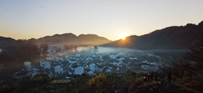 晨雾山村 日出金光洒白墙图片