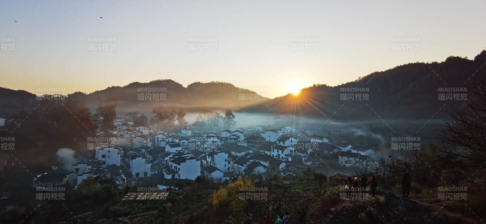 晨雾山村 日出金光洒白墙图片