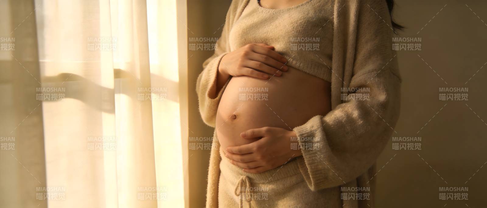 孕妈妈轻抚 belly 阳光温柔洒落图片