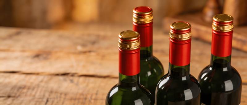 红酒瓶列木桌 红帽金封显雅致图片