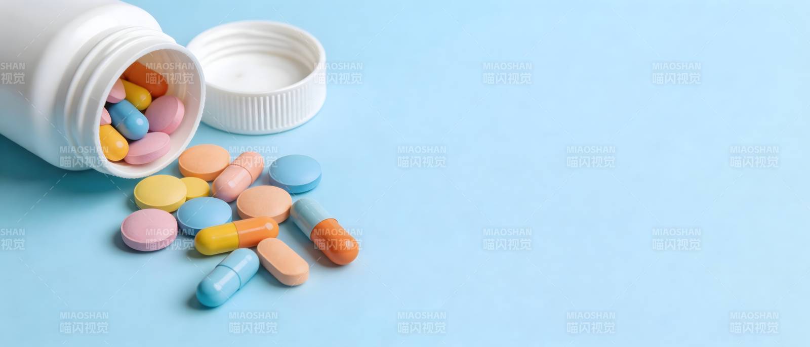 药瓶倾倒 彩片散落蓝底图片