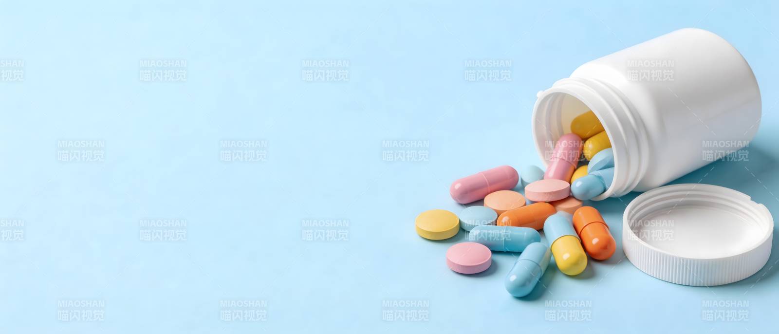 药瓶倾倒 彩药散落蓝底图片