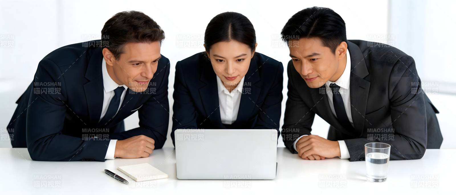 三人围看笔记本讨论工作图片