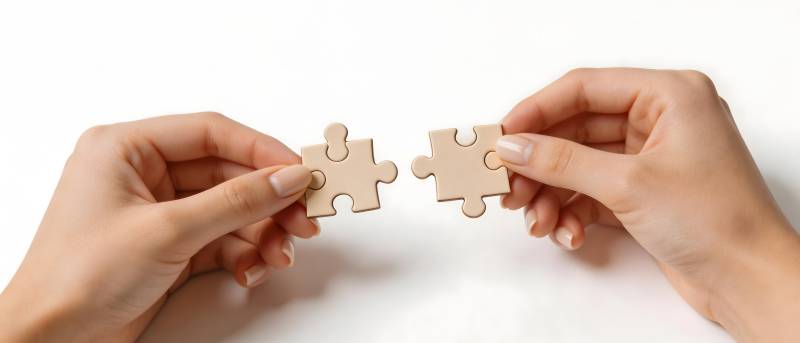 双手拼合两块拼图图片