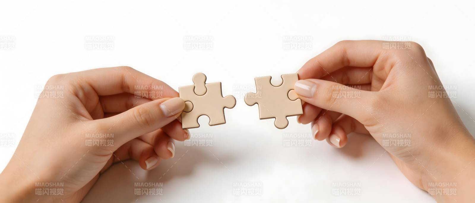 双手拼合两块拼图图片