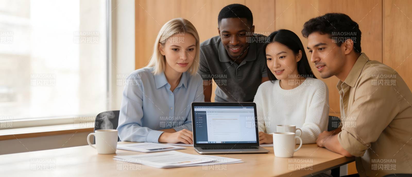 四人围桌共看笔记本图片