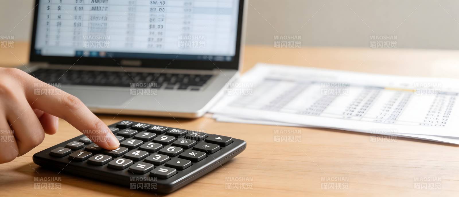手指按计算器 旁有电脑报表图片