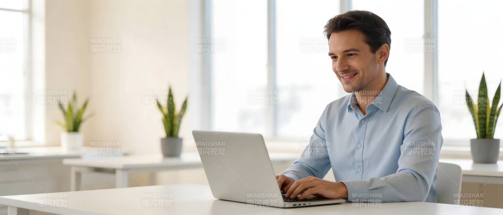 男子微笑用笔记本电脑办公图片