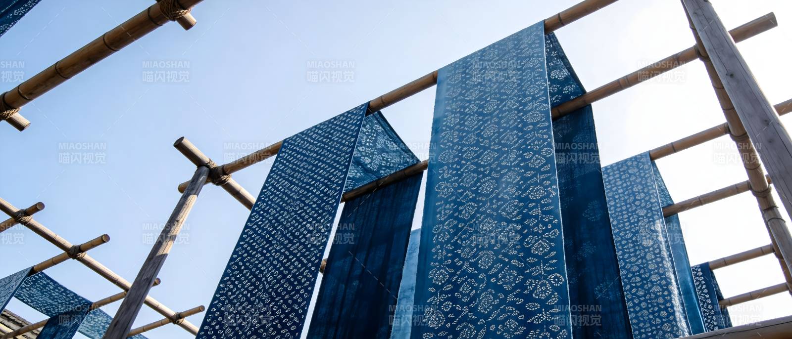 蓝染布晾晒于竹架之上图片