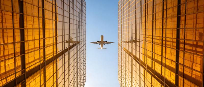 飞机穿楼间 金光映蓝天图片