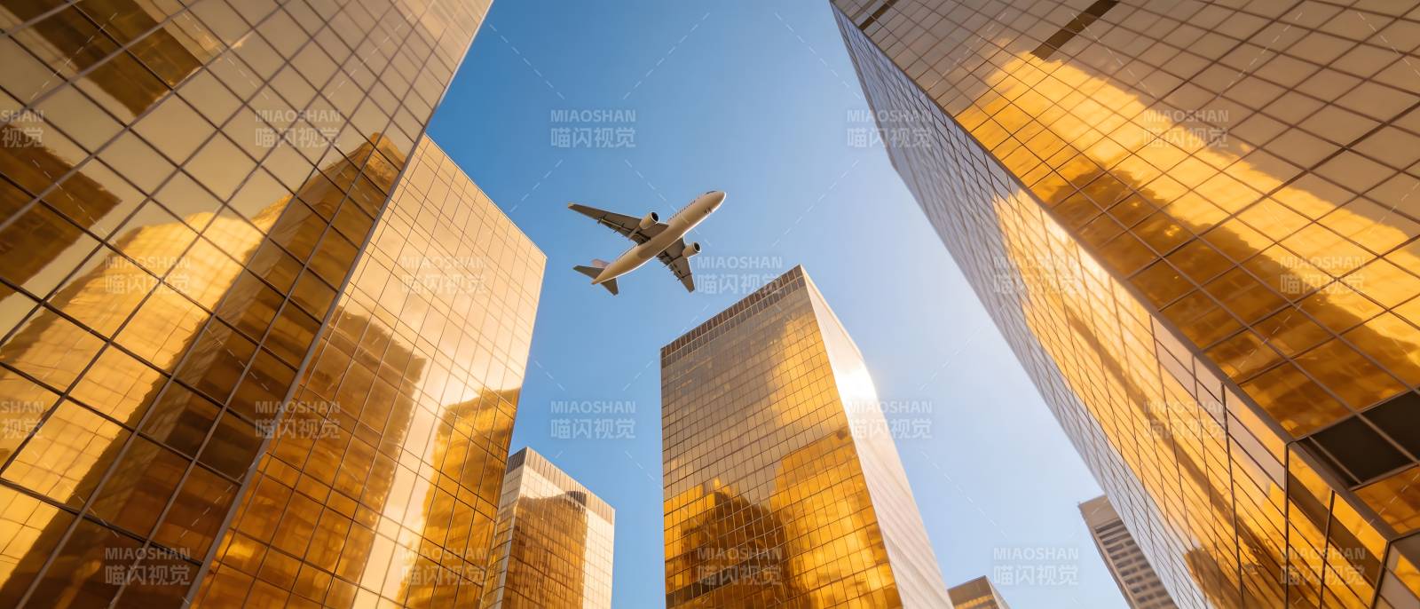 飞机掠过金色摩天楼群图片
