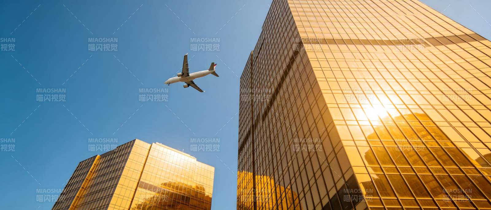 飞机掠过金色摩天楼图片
