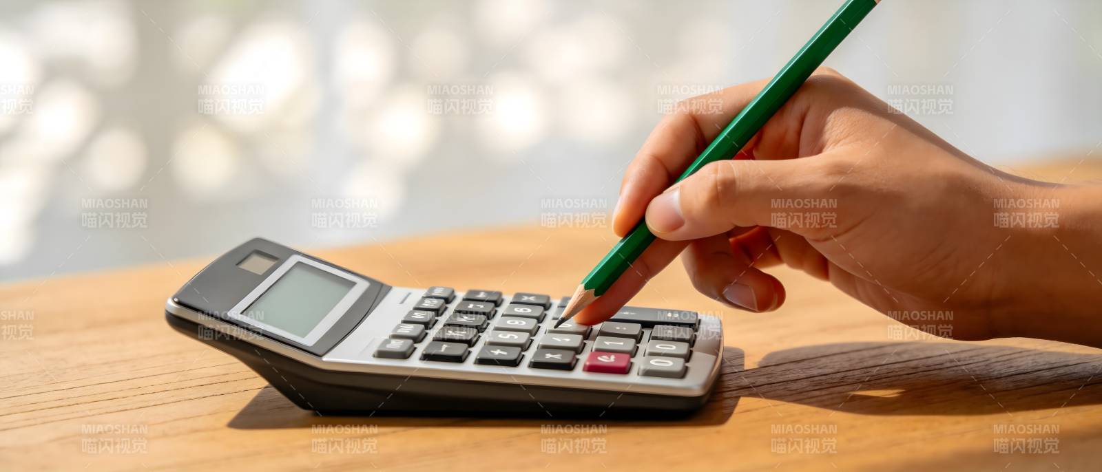 手持绿笔按计算器图片