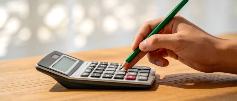 手持绿笔按计算器图片