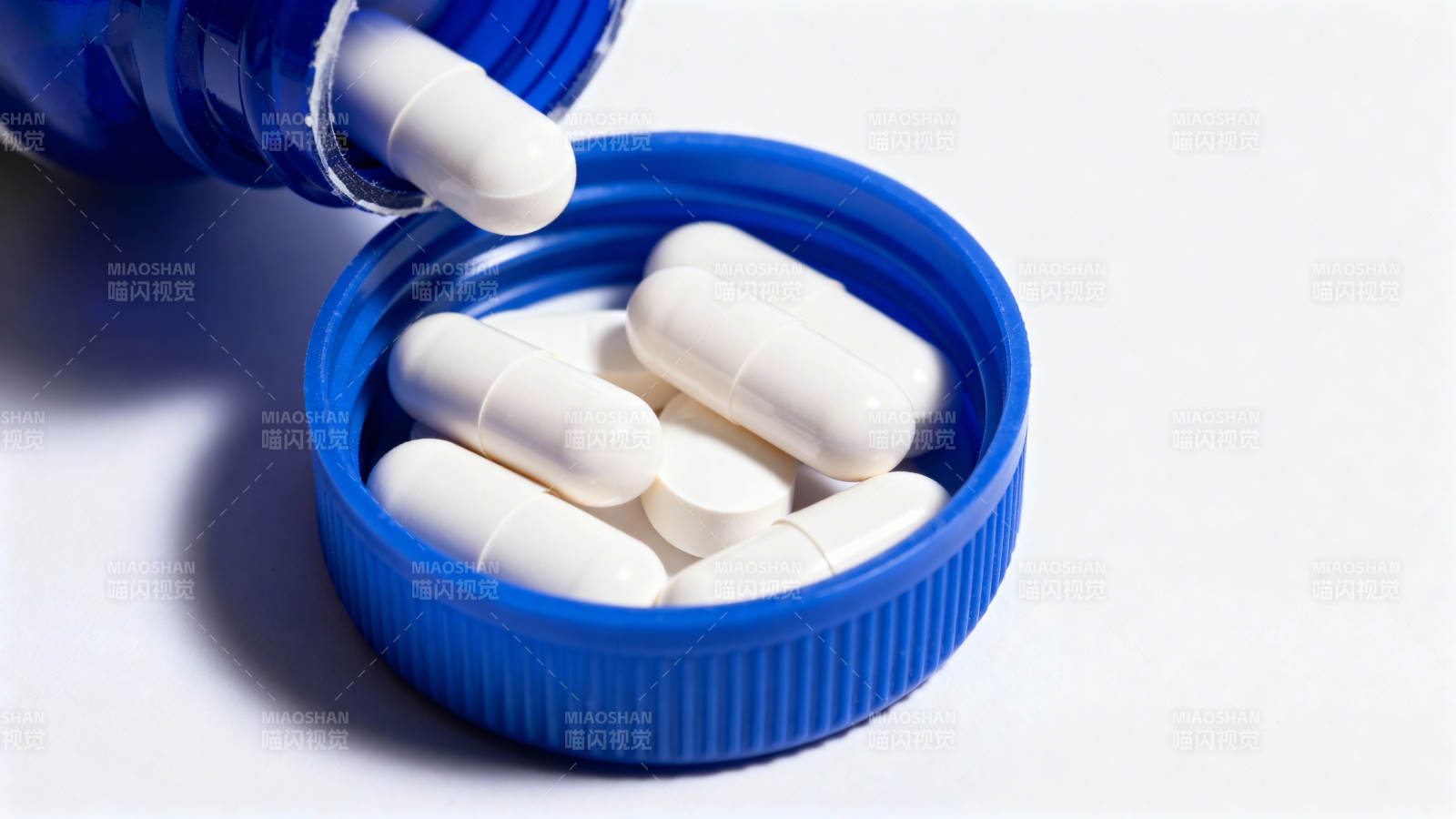 蓝色药瓶盖中的白色胶囊图片