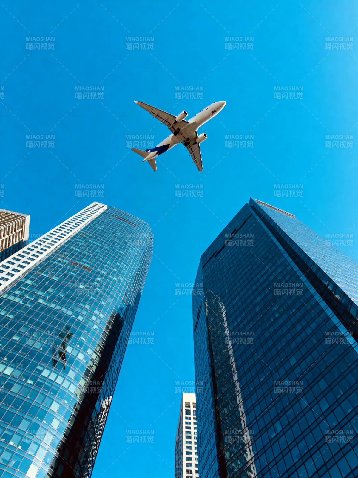 飞机掠过摩天楼群图片