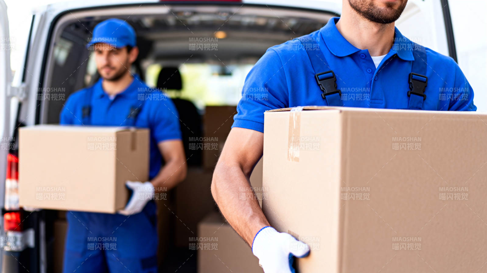 蓝衣快递员搬箱送货中图片