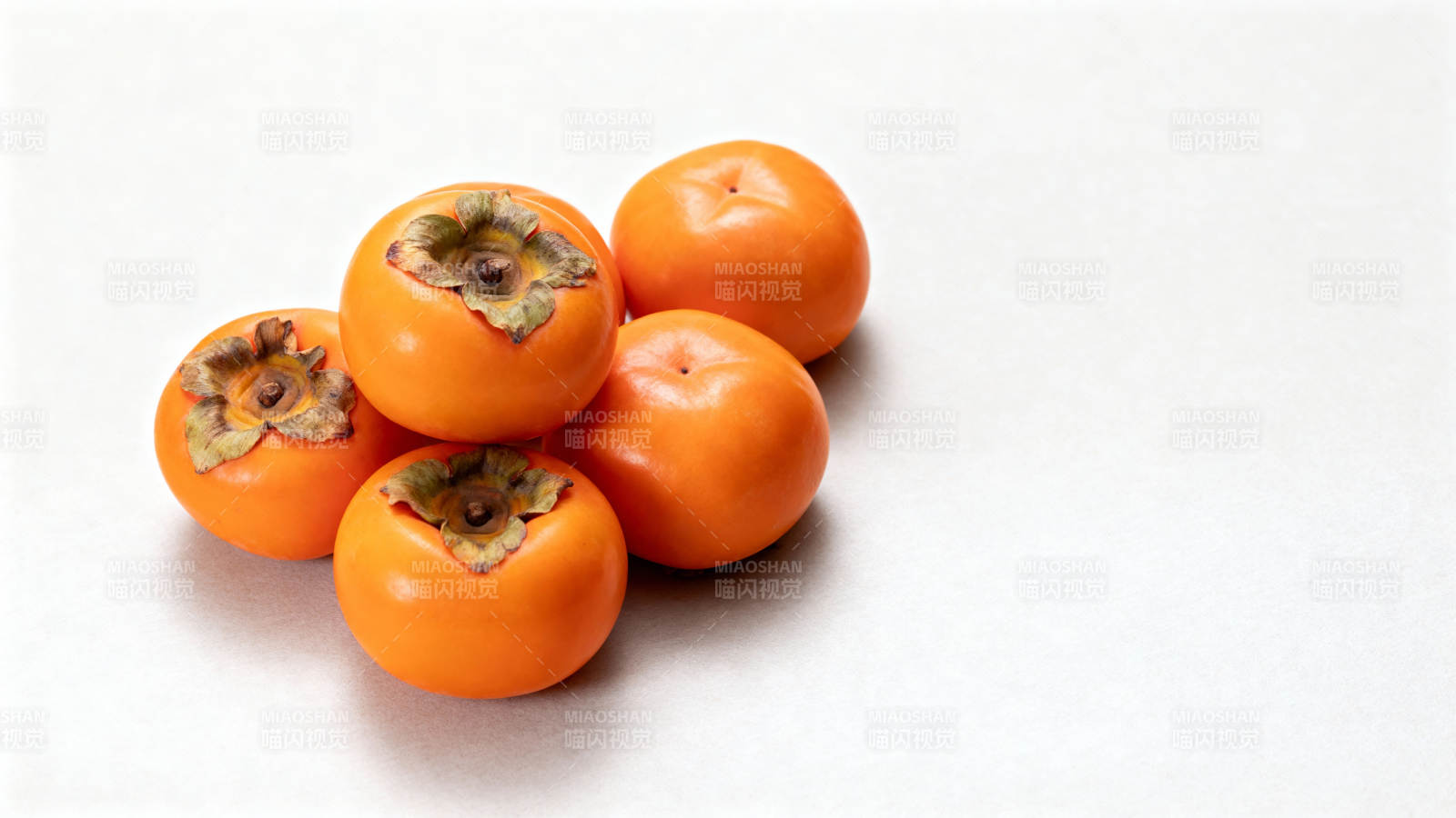 五颗橙红柿子静置白底图片
