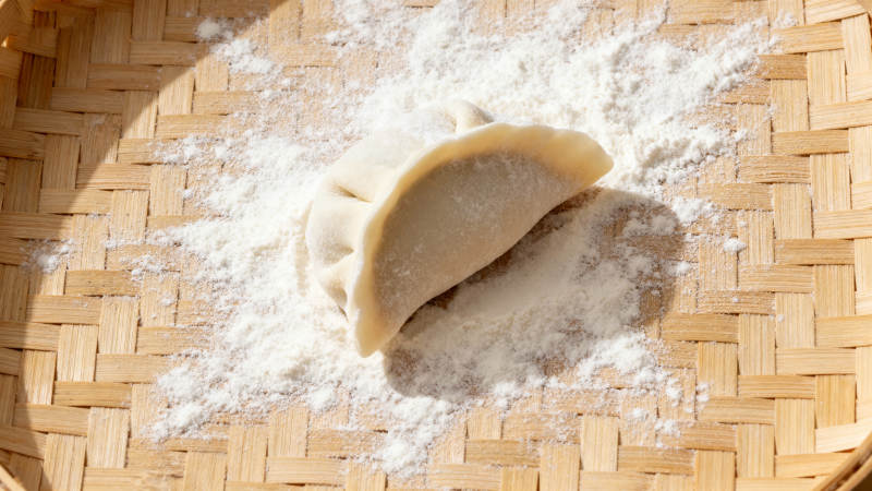 竹筛上的饺子与面粉图片