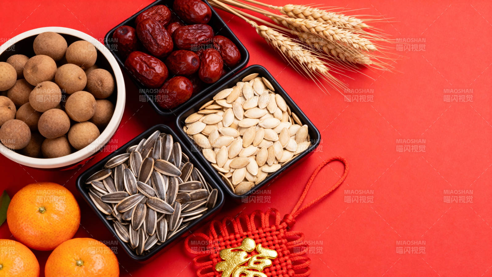 年货坚果红枣橘子麦穗红底图片