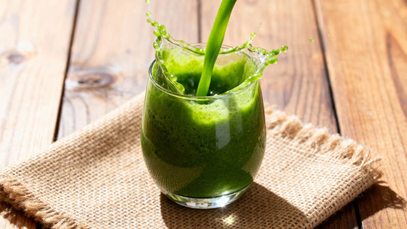 绿汁倾入杯 木桌布衬鲜图片