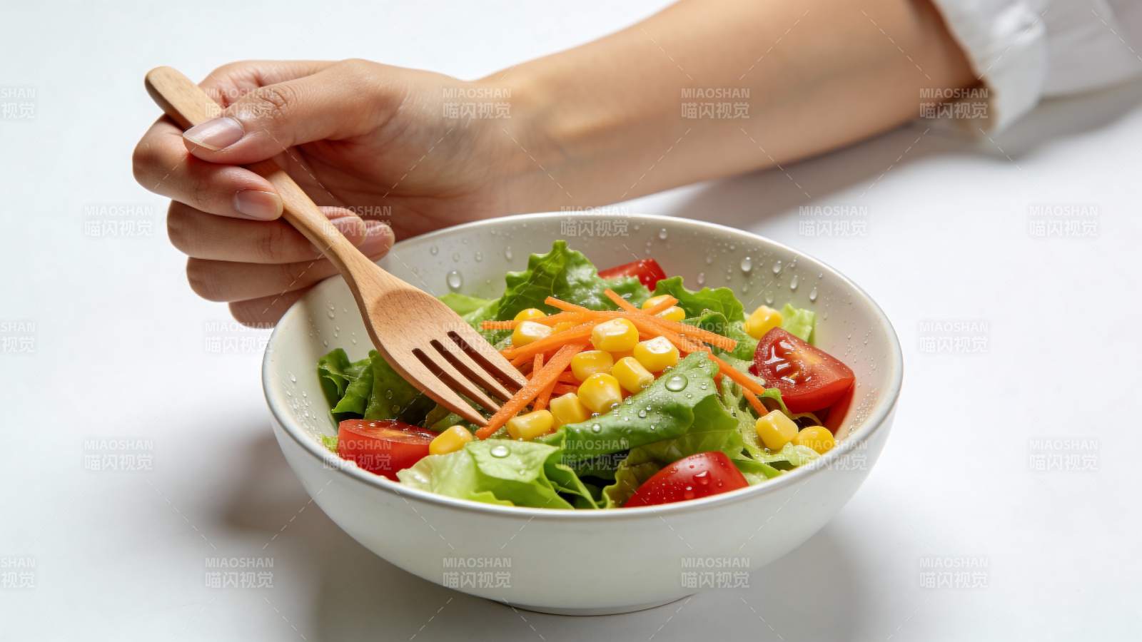 手握木叉享蔬菜沙拉图片