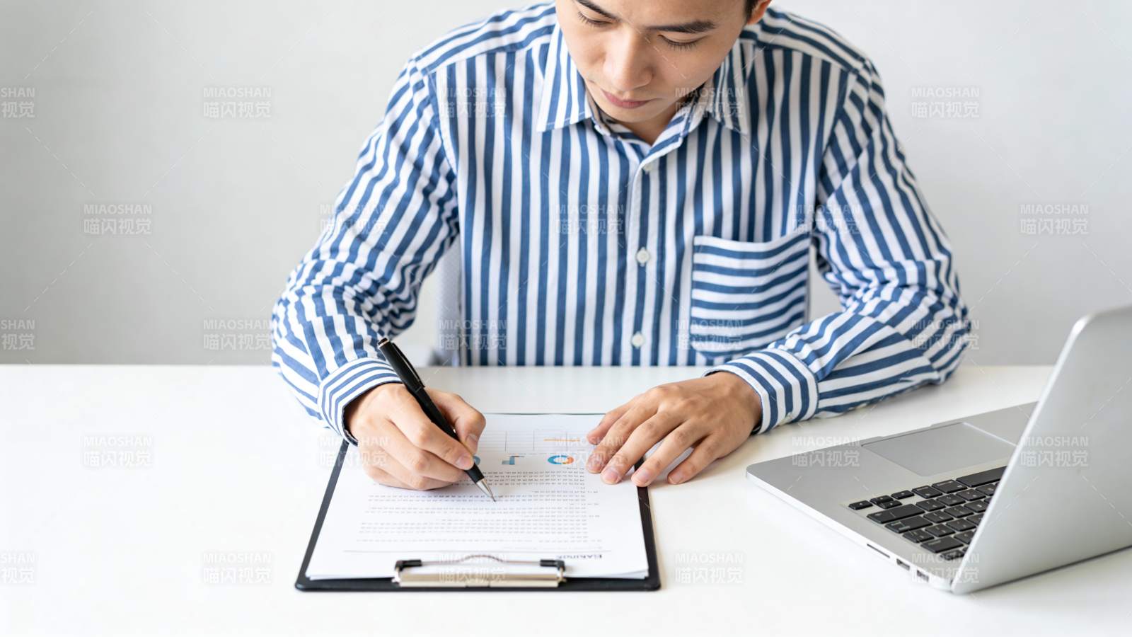 商务男士办公桌前书写文件图片