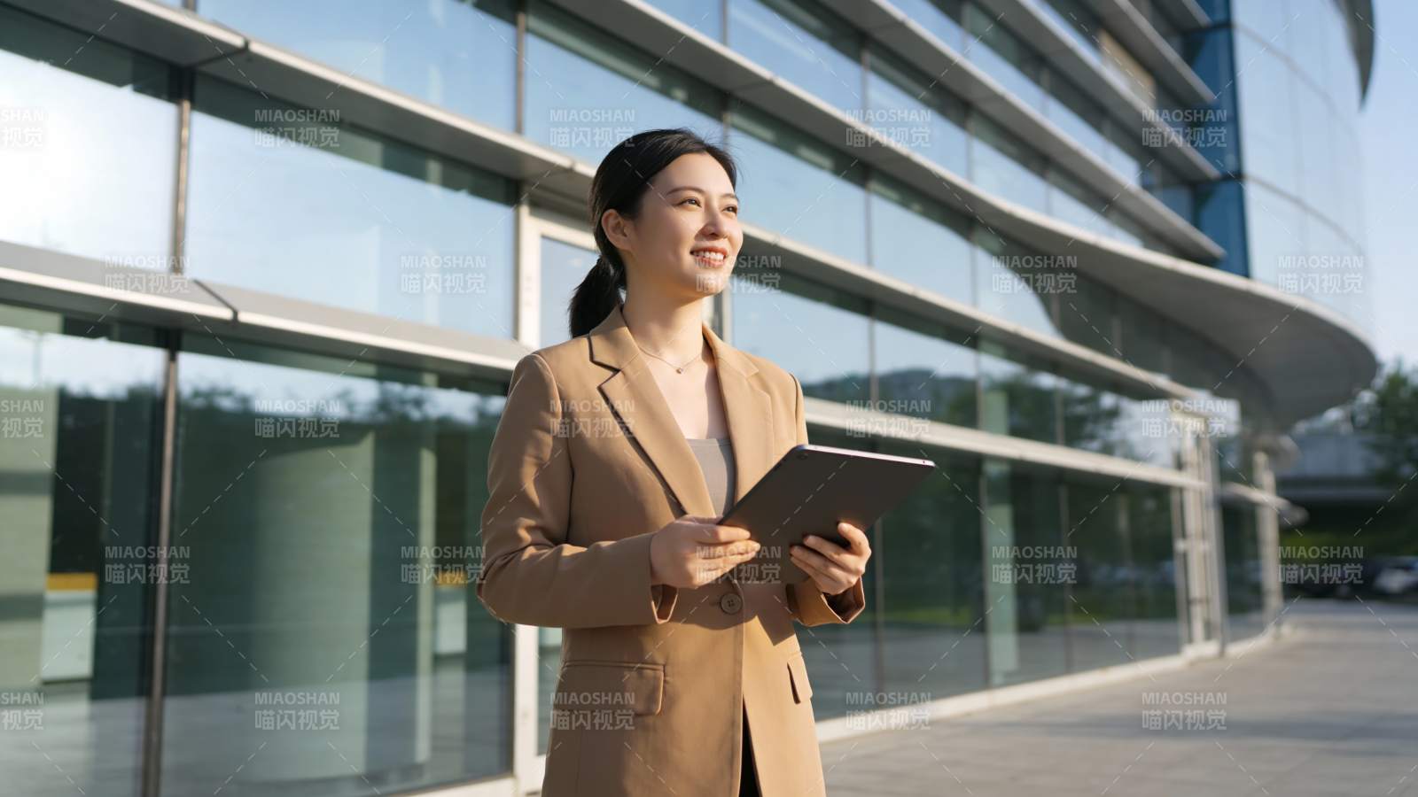 职场女性持平板微笑前行图片